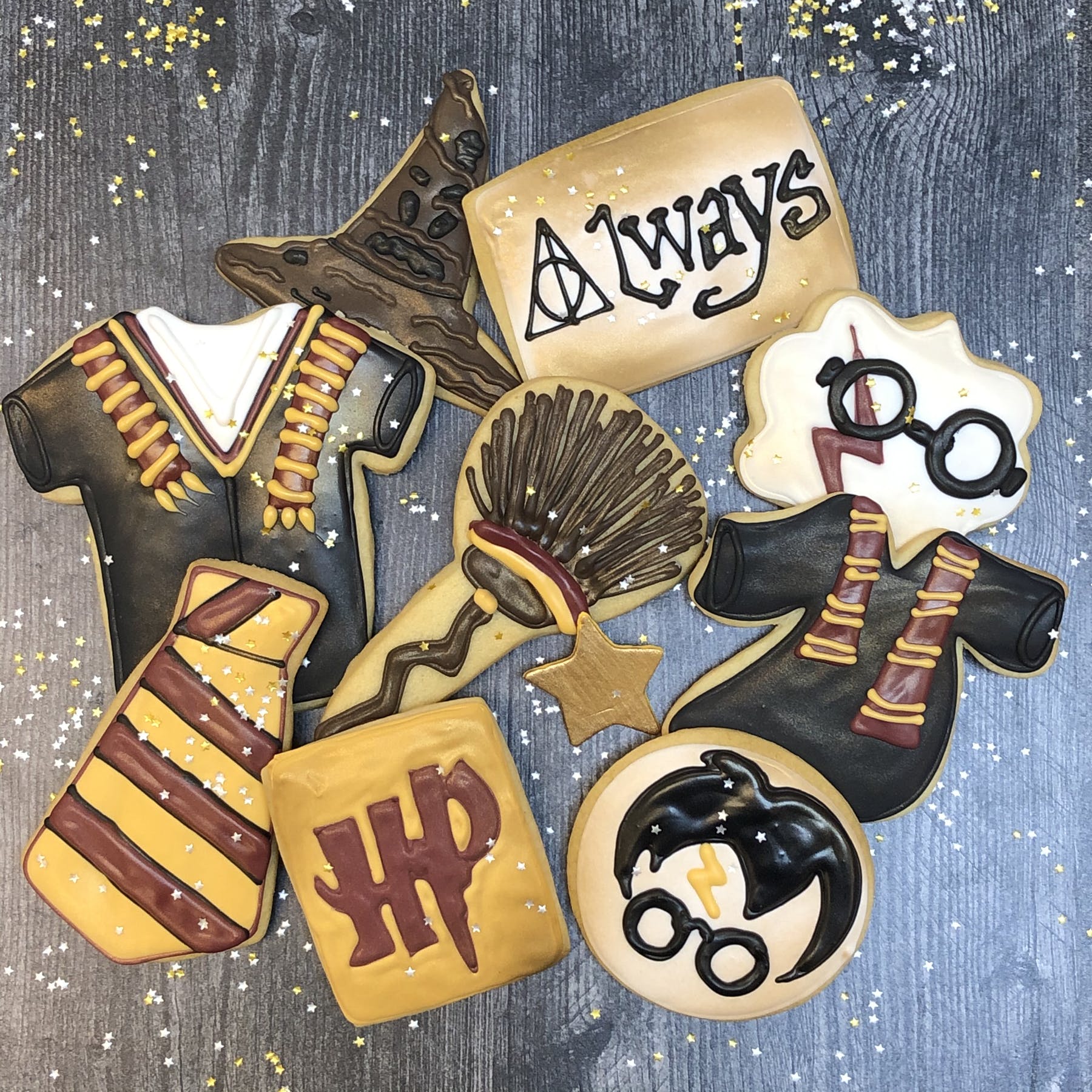 Assorted Harry Potter cookies with icing designs on wood background.