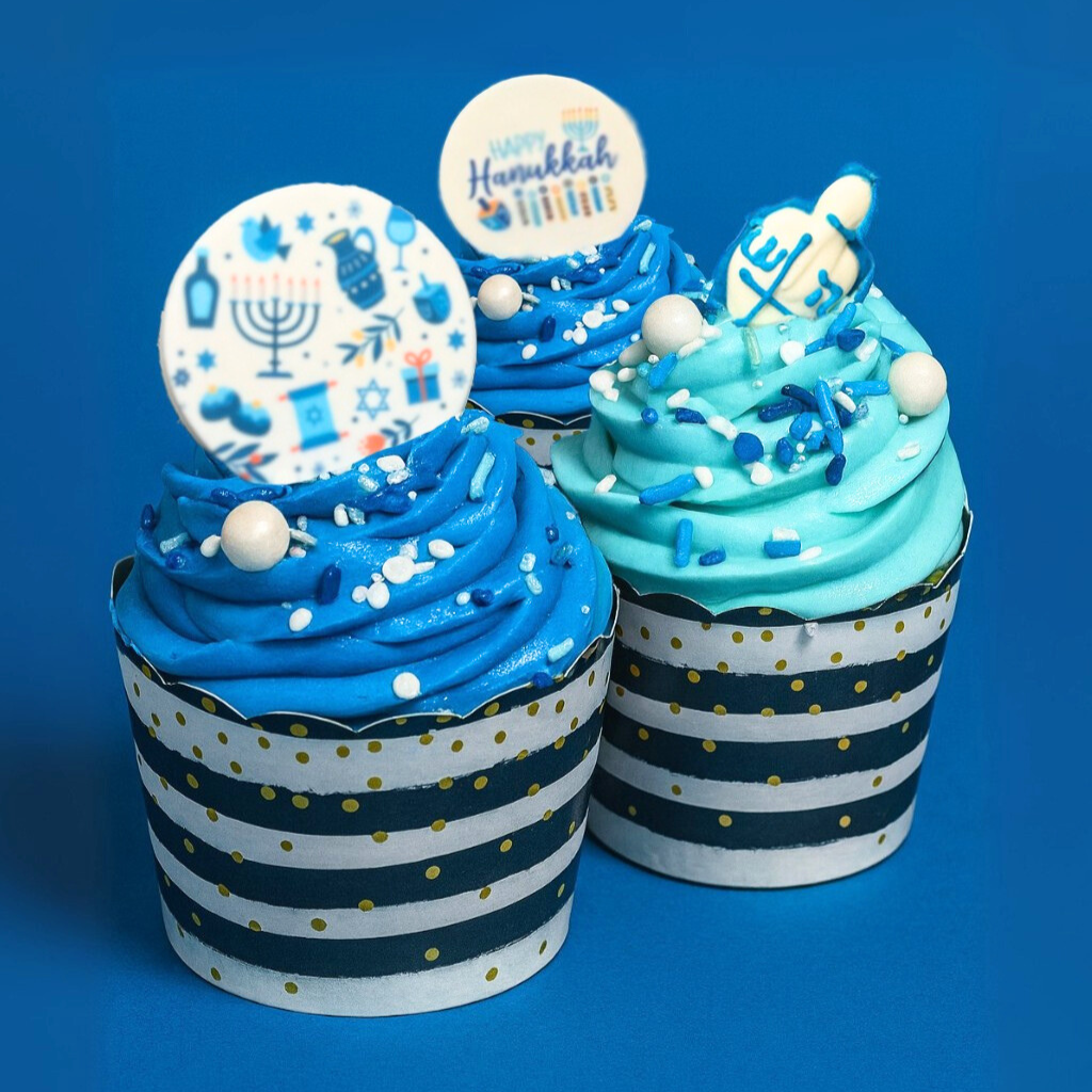 Hanukkah cupcakes with blue frosting and festive toppers.