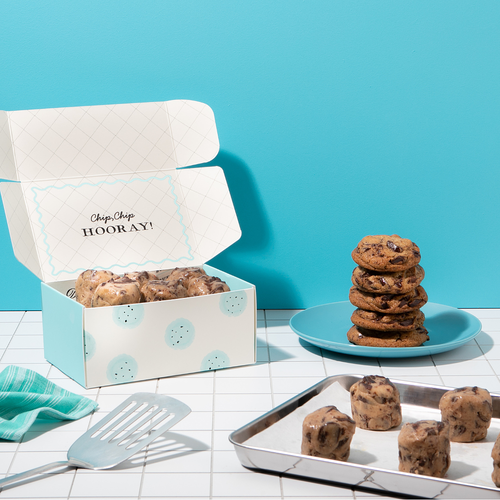 Chocolate Chunk Dough by DG in a box with baked cookies on a plate.