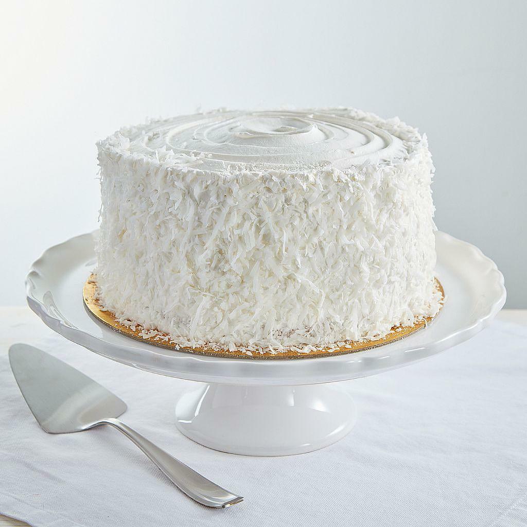 9-inch coconut cream cake covered in shredded coconut flakes