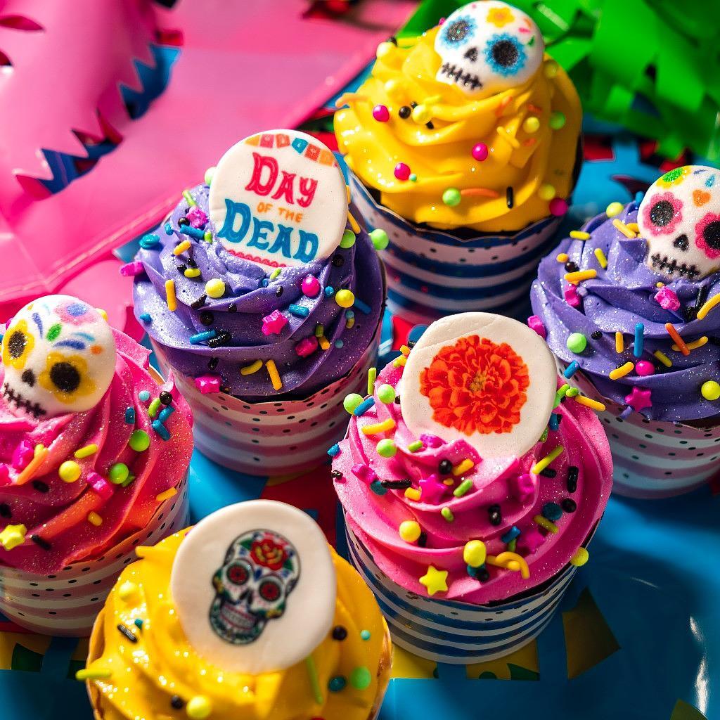 Day of the Dead cupcakes with colorful frosting and sugar skulls.