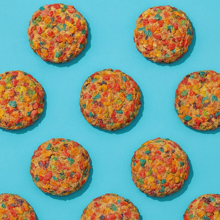 Fruity Pebble Dough cookies arranged on a blue background.