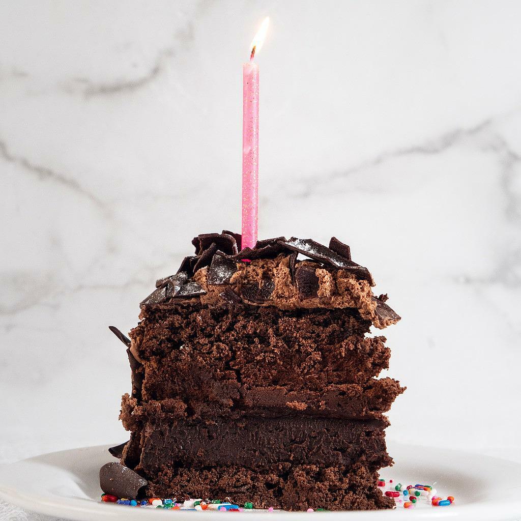 Cosmic Birthday Cake, 9-inch, with a lit pink candle.