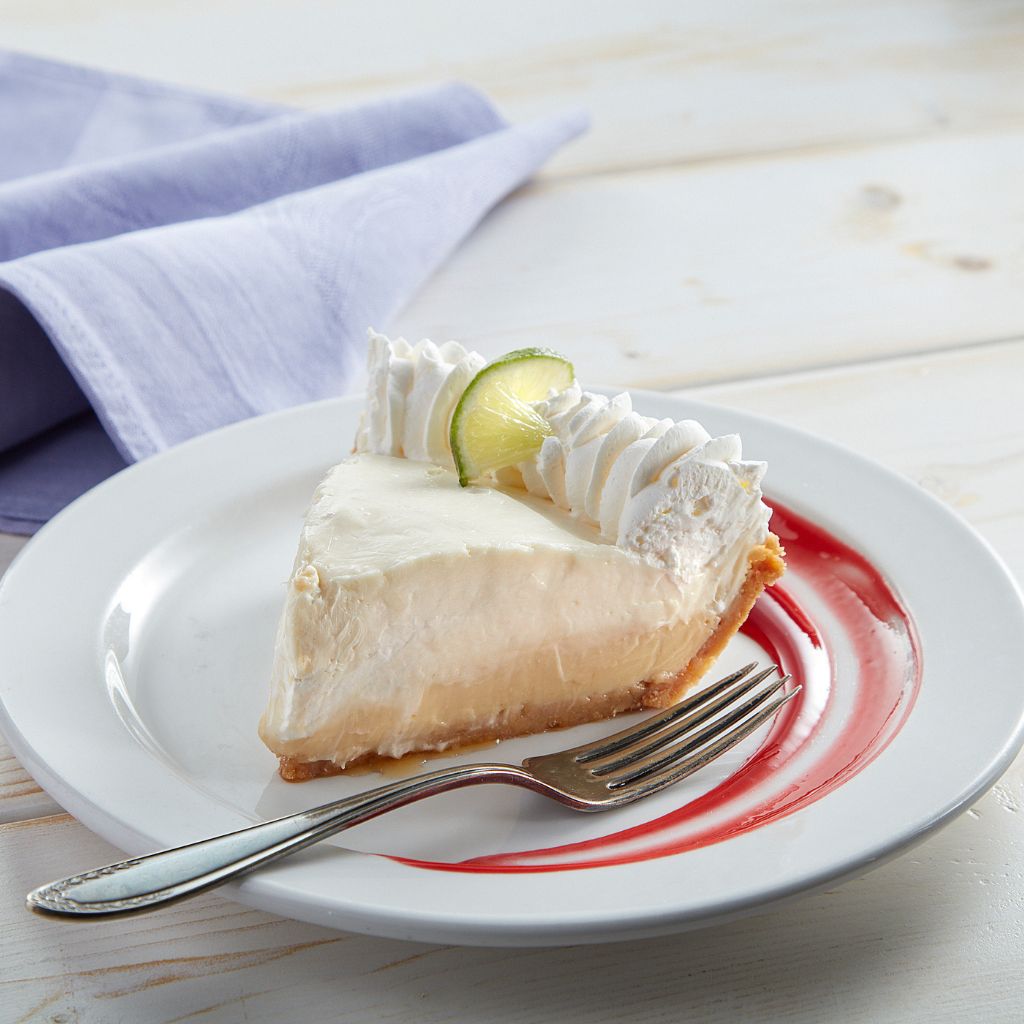 Double Decker Key Lime Pie slice with whipped cream and lime.