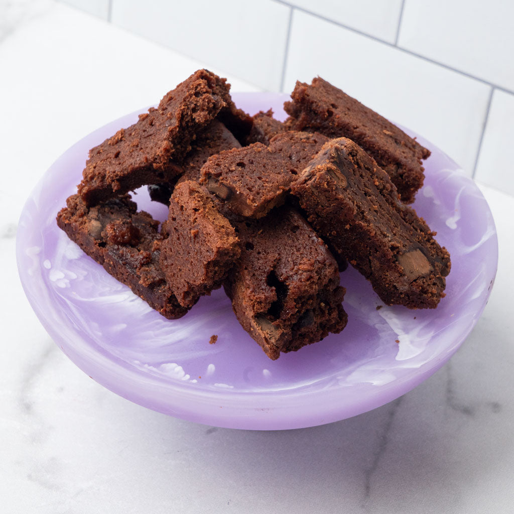 Edges chocolate brownie pieces on a purple plate