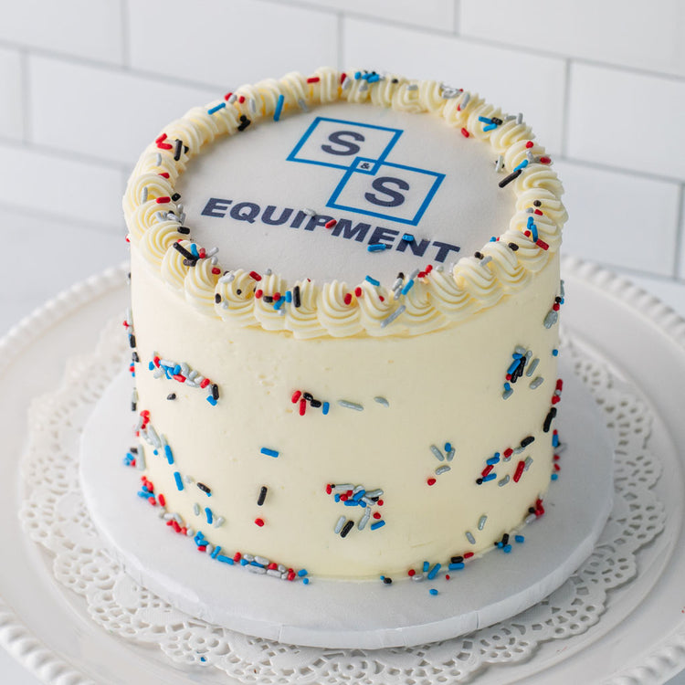 6-inch custom logo cake with white frosting and sprinkles