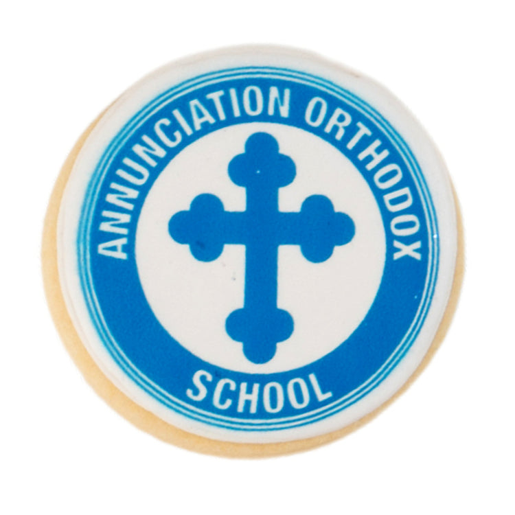 Round graduation cookie with blue school logo and cross.