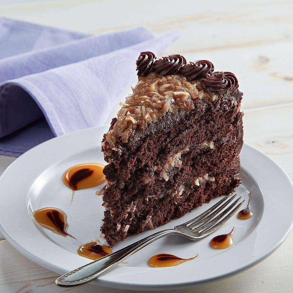 Slice of German chocolate cake on a white plate with a fork