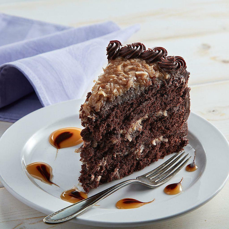 German Chocolate Cake slice with coconut pecan frosting on a plate.