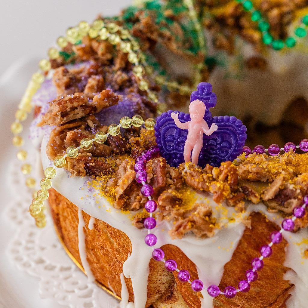 Mardi Gras 2025 king cake with pecans and purple crown topper