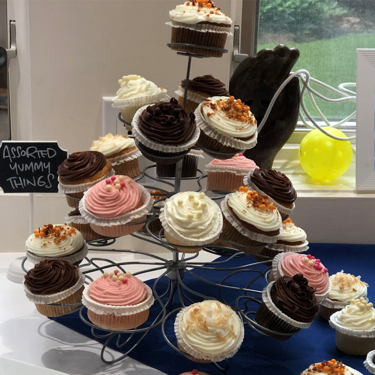 Mini red velvet cupcakes on a tiered metal display stand.