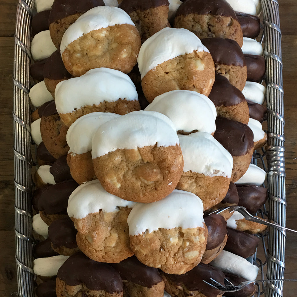Miniature cookies dipped in white and dark chocolate on a tray.