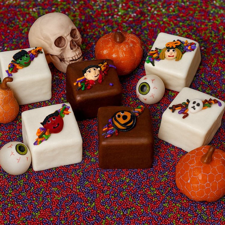 Halloween petit fours decorated with spooky icing figures.