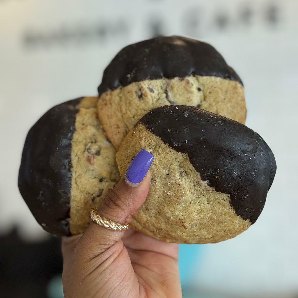Chocolate-dipped chocolate chunk cookies held in hand