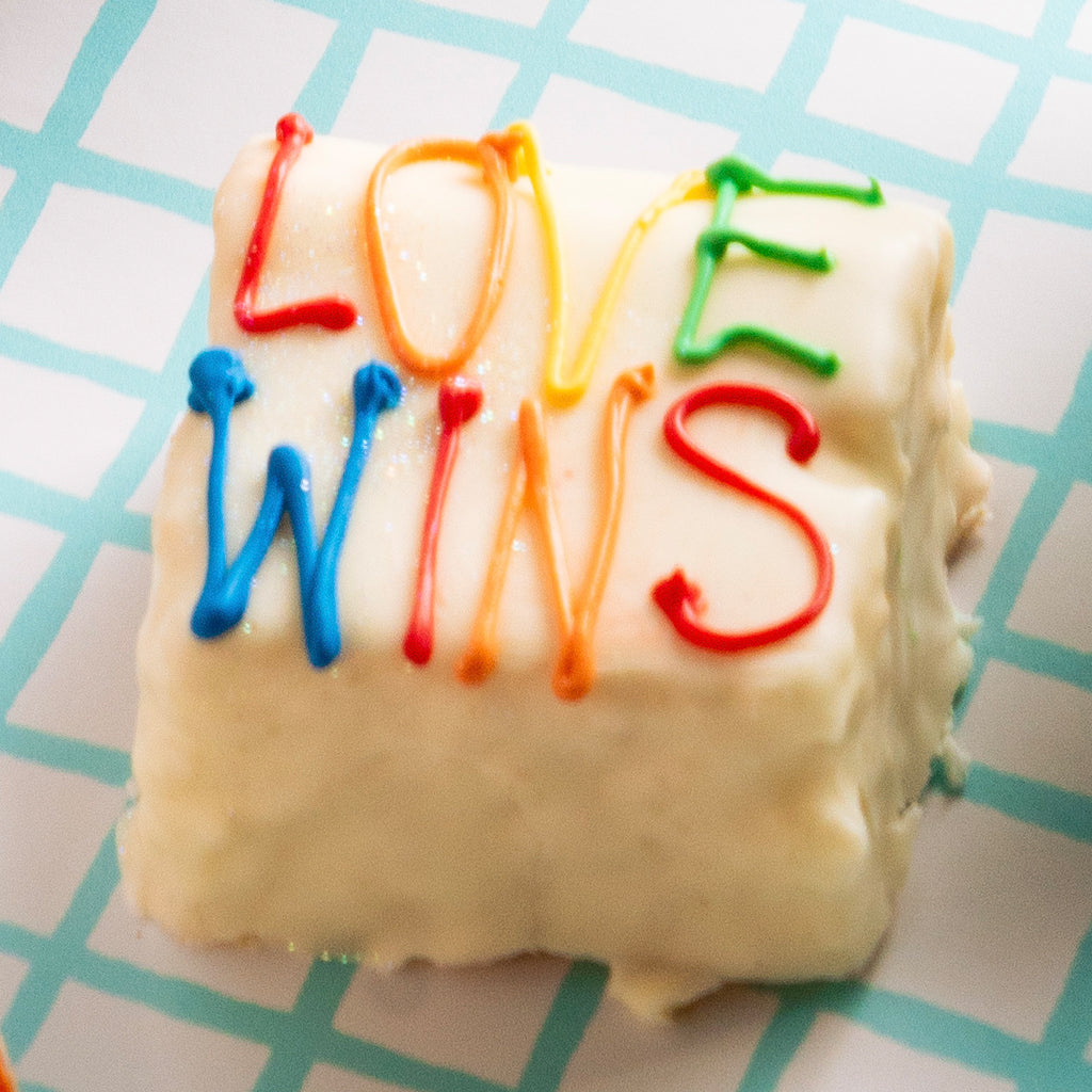 Pride Petit Four with Love Wins icing on a grid background
