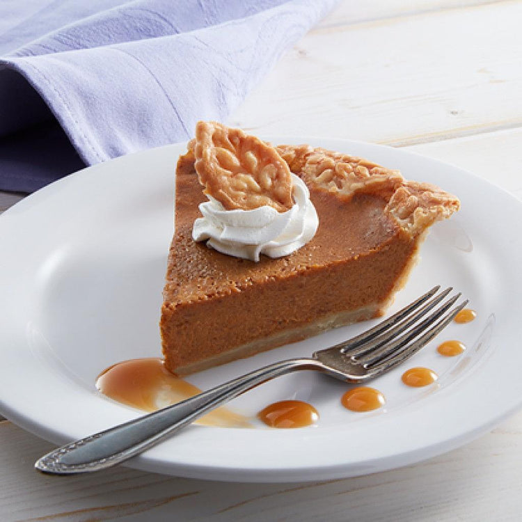 Rustic pumpkin pie slice with whipped cream on a white plate