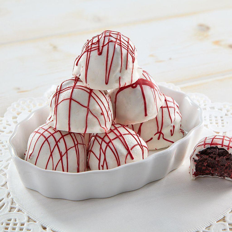Red velvet cake balls with white chocolate and red drizzle.