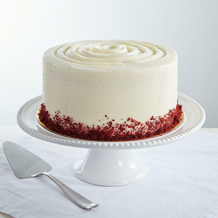 9-inch red velvet cake with white frosting on a cake stand
