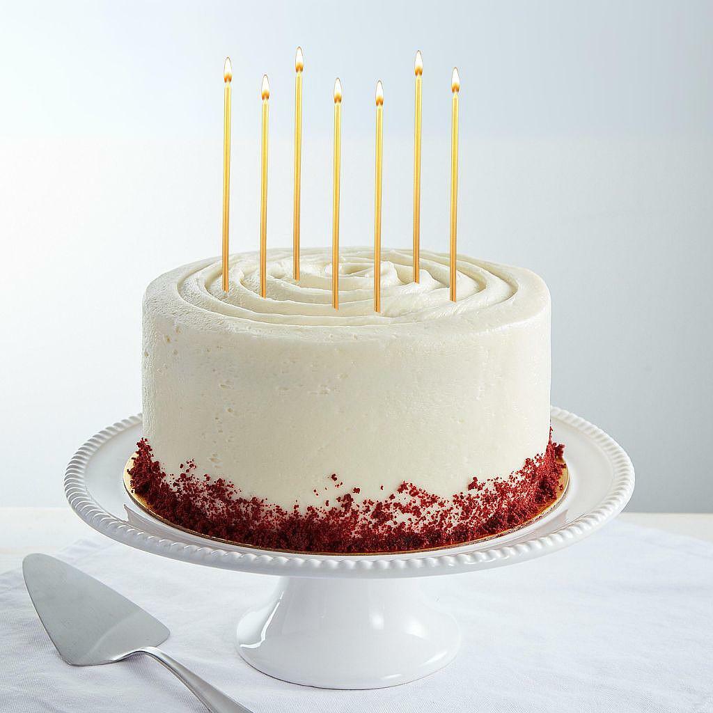 9-inch red velvet cake with white frosting and gold candles