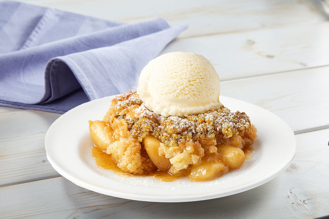 Apple cobbler topped with a scoop of vanilla ice cream