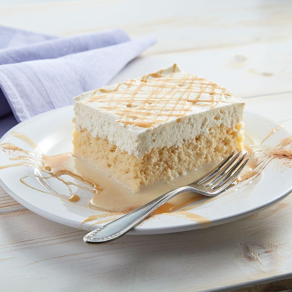 Tres leches cake slice with caramel drizzle on a plate