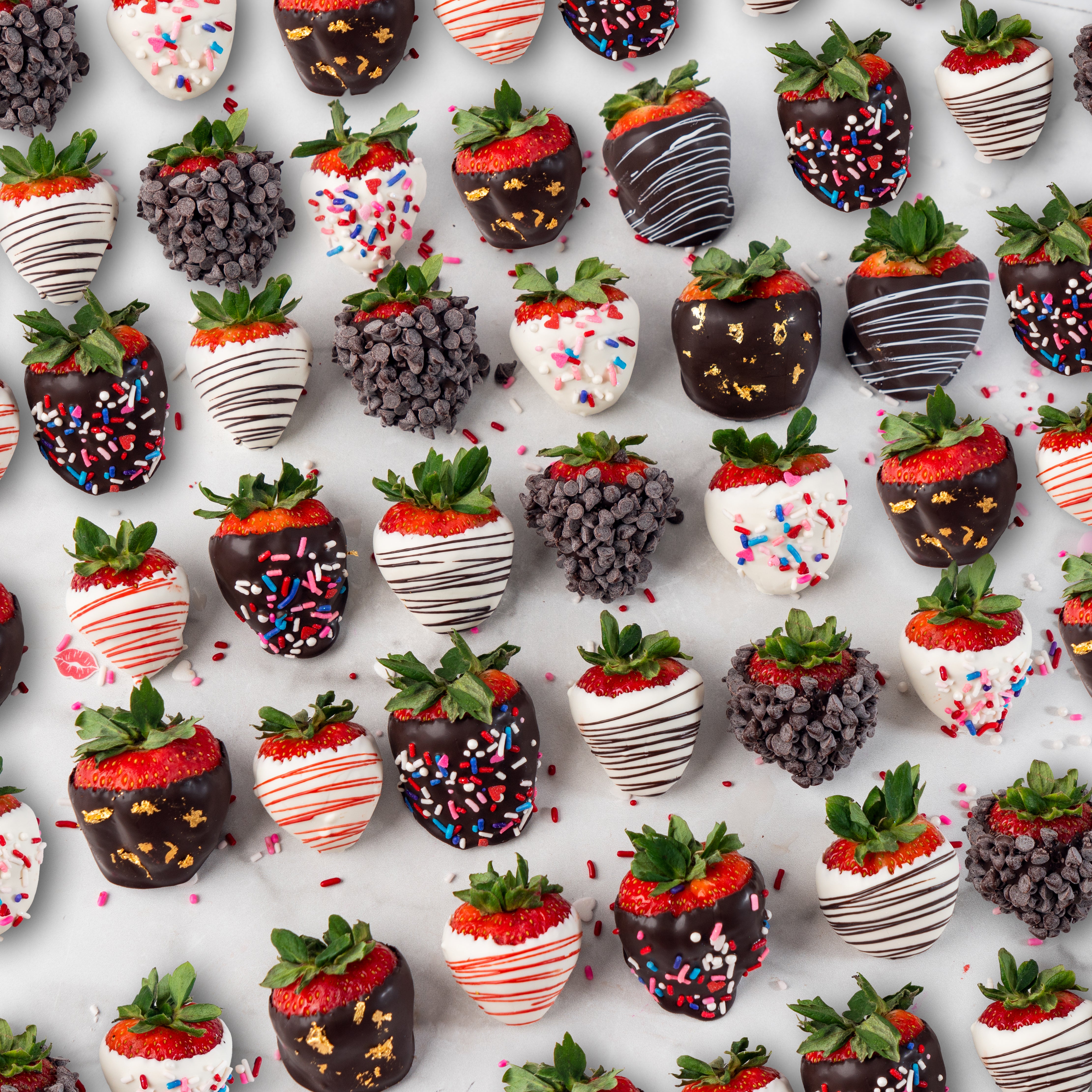 Individual chocolate-dipped strawberries with assorted toppings.