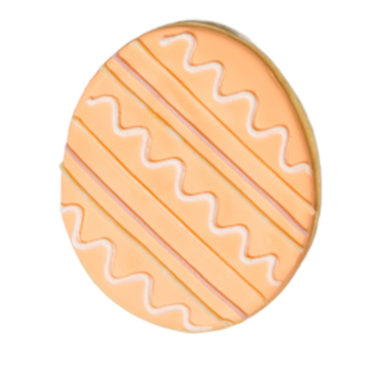 Easter butter cookie shaped like an egg with orange icing.