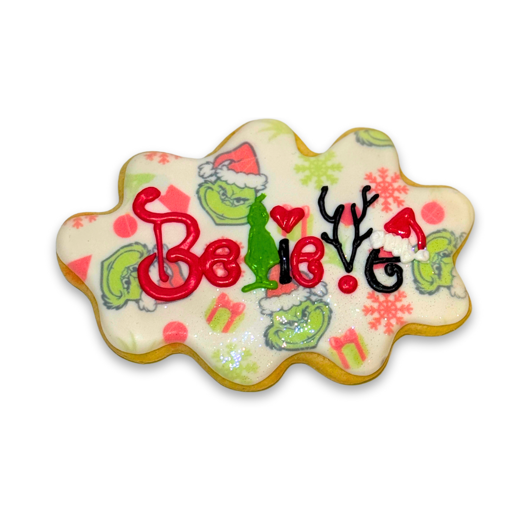 Merry Grinchmas Believe cookie with festive icing design.