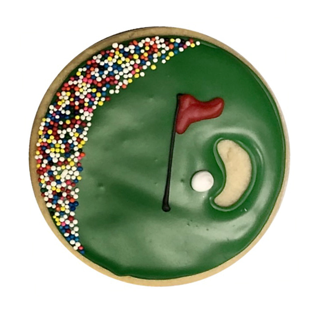 Golf birthday gift box cookie with green icing and sprinkles.