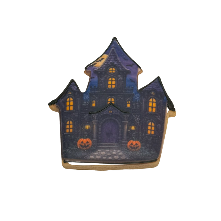 Halloween cookie shaped like a haunted house with pumpkins.