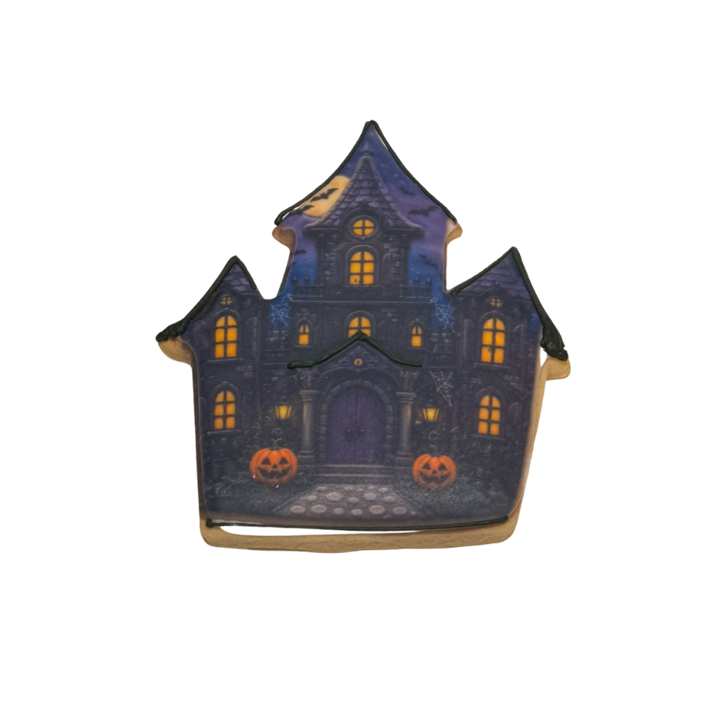 Halloween cookie shaped like a haunted house with pumpkins.