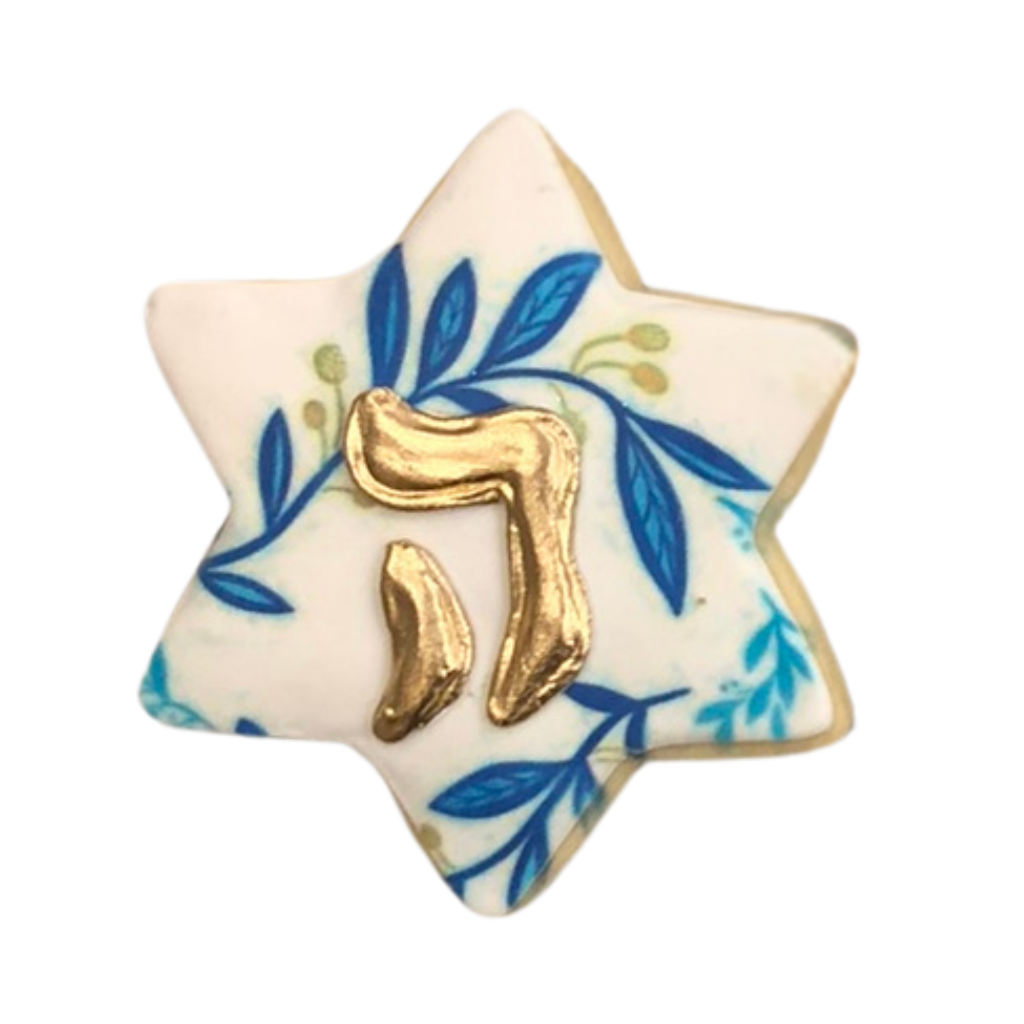 Star-shaped Hanukkah cookie with blue leaves and gold Chai.