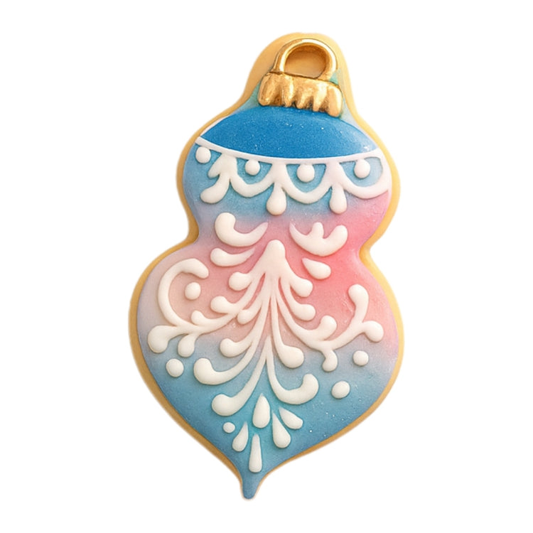 Ornament cookie with blue and pink ombre icing and white filigree.