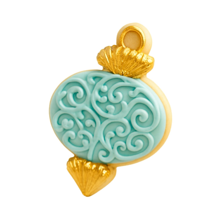 Ornament cookie with blue scrollwork and gold accents