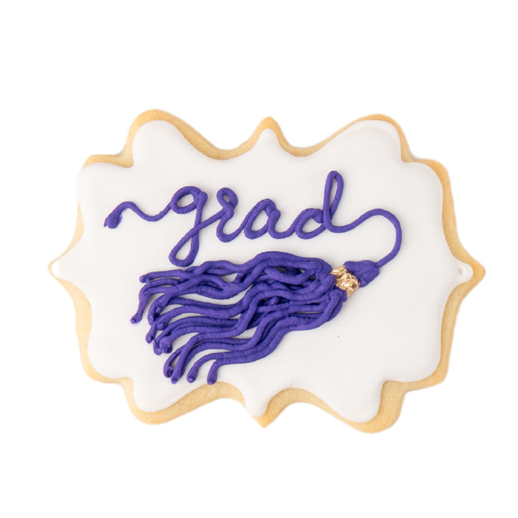Graduation tassel cookie with purple icing on white background