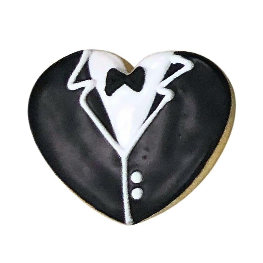 Heart-shaped cookie decorated like a black tuxedo.