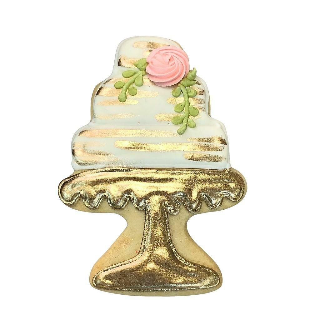 Wedding cake cookie with gold accents and a pink rose.