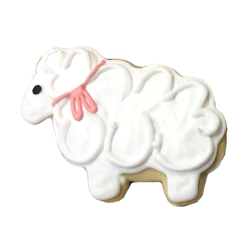 Sheep-shaped sugar cookie with white icing and a pink bow.
