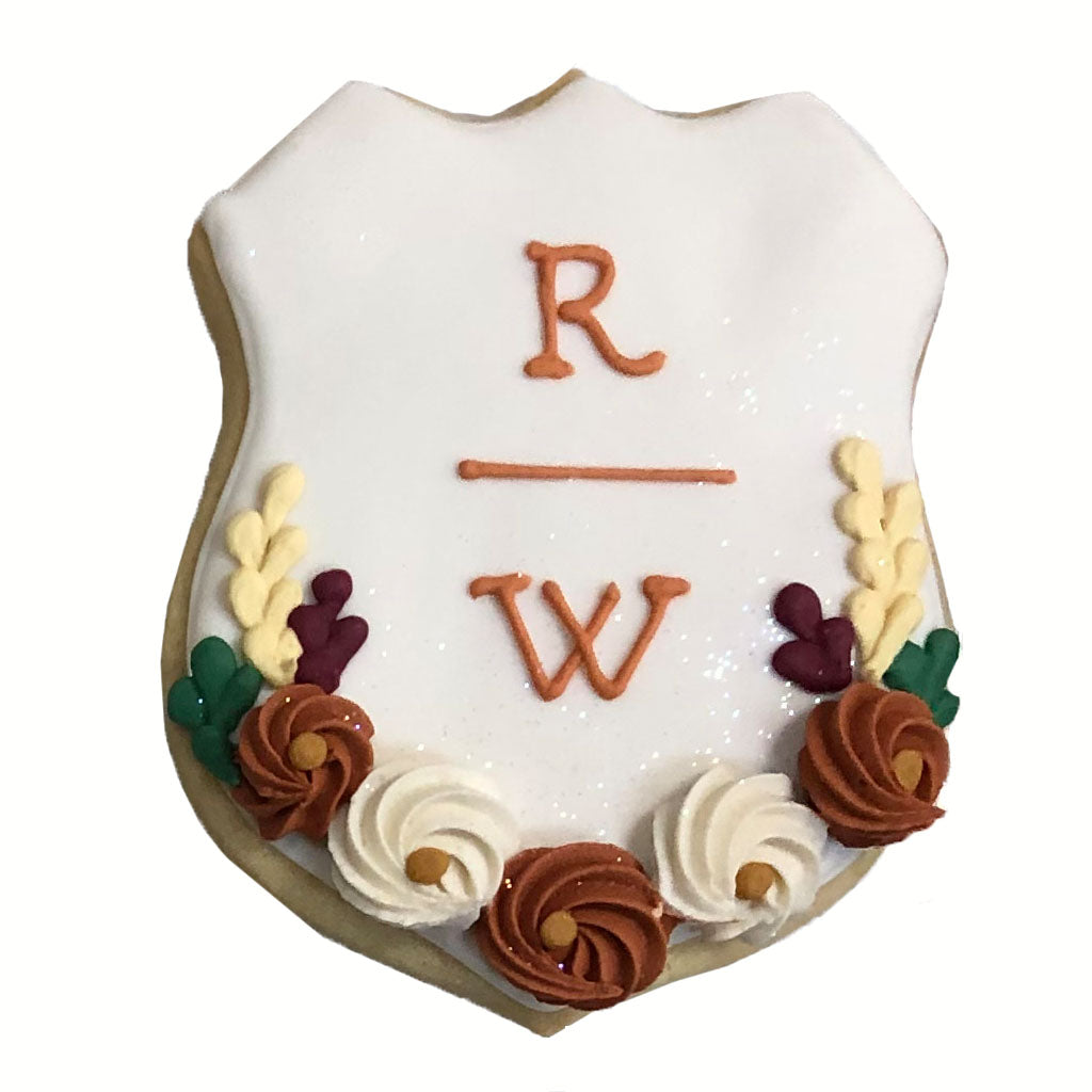 Wedding plaque cookie with initials and floral icing details.
